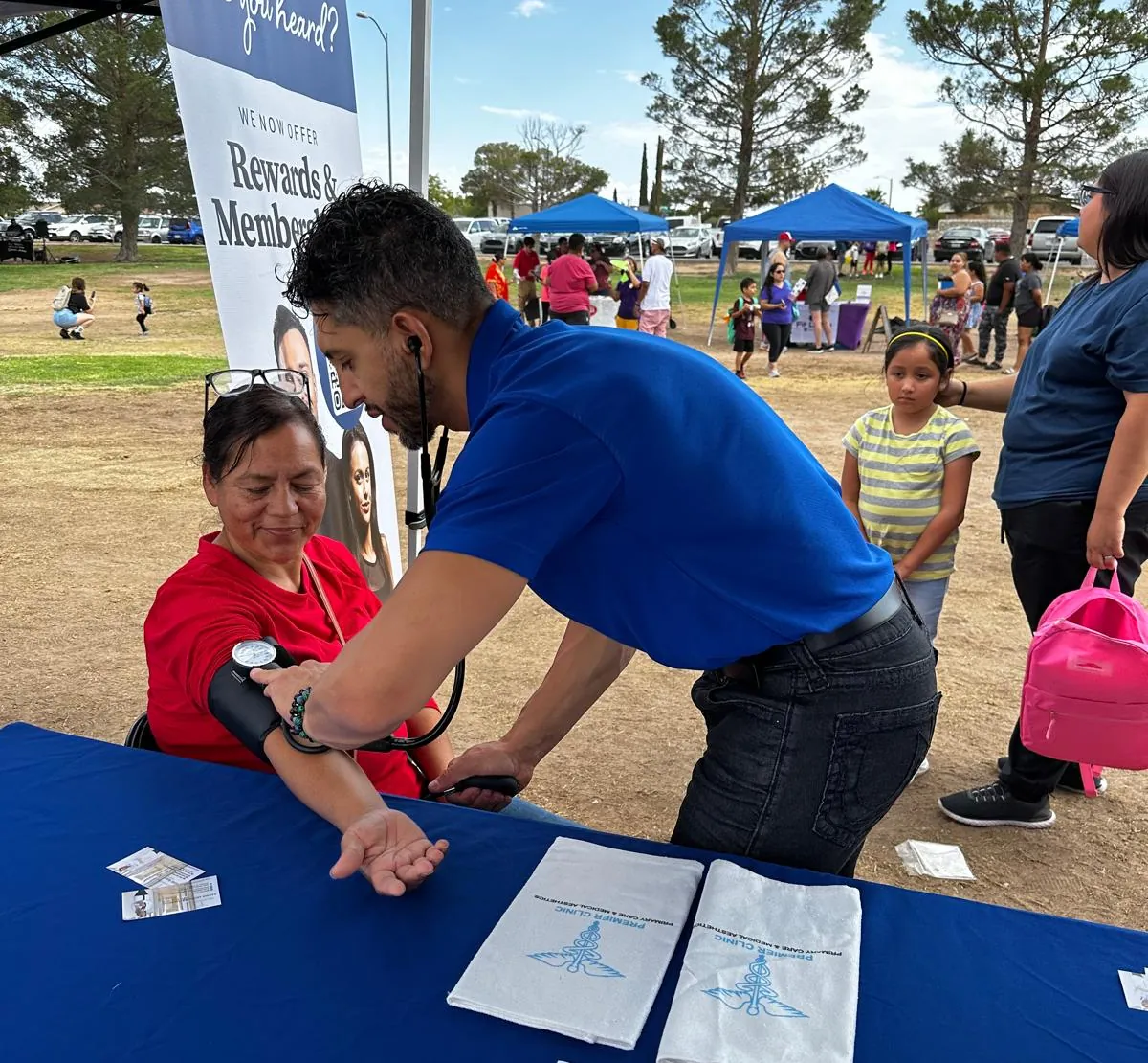 A Premier clinician checking blood pressure at an outdoor event